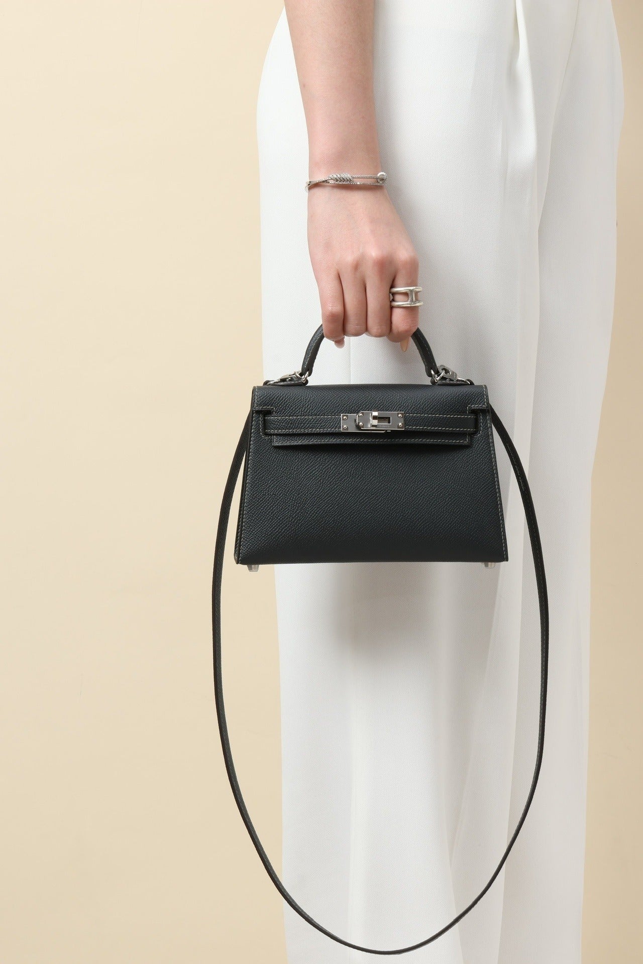 Woman holding the Mini Leather Elegance handbag by Lorvien Maison, showcasing luxury and style.